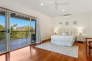 a bedroom with a bed and a large window at Breathtaking Panoramic Ocean Views in Yaroomba