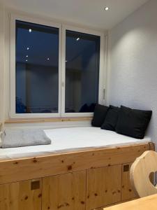 Bett in einem Zimmer mit einem großen Fenster in der Unterkunft Zum Rota Hus in Arosa