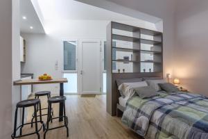 a bedroom with a bed and a desk and stools at Casa Melo Mini House in Bologna