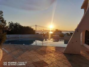 puesta de sol sobre una piscina en una villa en Sant'Antioco island Sea View an Exclusive Villa by the Sea with extra Privacy & Care en Maladroscia