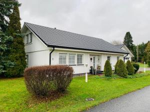 una casa blanca con techo negro en Central Apartment Närpes en Närpiö