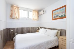 パルム・マールにあるVilla Palm Marのベッドルーム1室(白いベッド1台、窓2つ付)