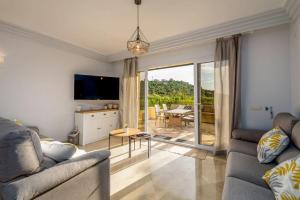 a living room with a couch and a television and a table at Spacious ground floor apartment in Casares Costa in Casares