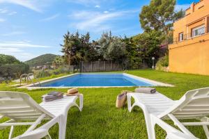 un patio con 2 sillas y una piscina en Apartaments Aiguablava, en Begur