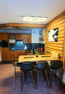 a kitchen with a wooden table and some chairs at Appartement ARC 1950 m, Ski au pied, piscine extérieure chauffée, remontées mécaniques à 100m, sauna et salle de sports in Arc 1950
