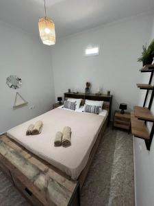 a bedroom with a large bed with slippers on it at Beach apartment Edem first floor in Perivolos
