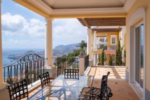 a balcony with chairs and a view of the ocean at Palheiro Village - Golf, Gardens & Spa in Funchal