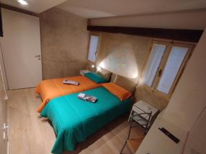 1 dormitorio con 1 cama con sábanas de color naranja y verde en Cà Lirica, en Venecia