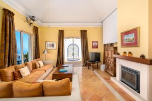 a living room with a couch and a fireplace at Palheiro Village - Golf, Gardens & Spa in Funchal