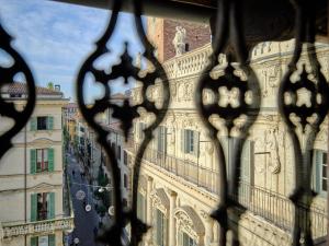 een uitzicht op een gebouw door een ijzeren hek bij ApartmentsArena - Residenza Degli Scaligeri - Piazza Erbe in Verona