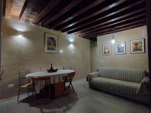een woonkamer met een tafel en een bank bij Cà Lirica in Venetië
