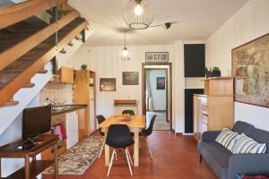 eine Küche und ein Wohnzimmer mit einem Tisch und einem Sofa in der Unterkunft Little Brick House on Siena Hills with Balconies in Siena