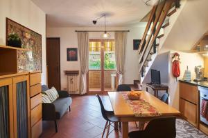 eine Küche und ein Wohnzimmer mit einem Tisch und Stühlen in der Unterkunft Little Brick House on Siena Hills with Balconies in Siena
