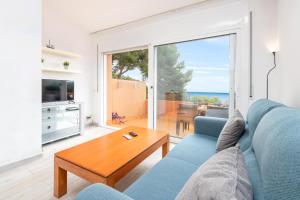 uma sala de estar com um sofá azul e uma mesa em Apartaments Aiguablava em Begur