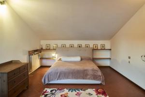 ein Schlafzimmer mit einem Bett und einer Holzkommode in der Unterkunft Little Brick House on Siena Hills with Balconies in Siena