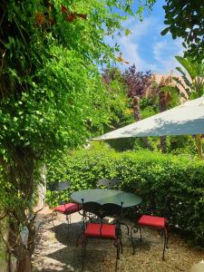 une table verte avec des chaises et un parasol dans l'établissement Hôtel Sainte Valérie Adults Only, à Juan-les-Pins