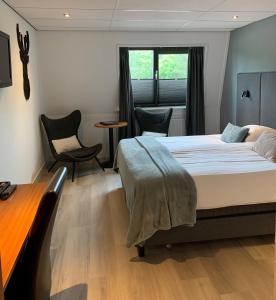 een slaapkamer met een bed en een tafel en stoelen bij Hotel Wapen van Delden in Delden