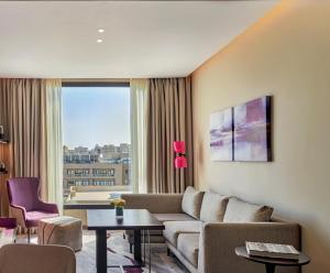 a living room with a couch and a large window at Crowne Plaza - West Cairo Arkan, an IHG Hotel in 6th Of October