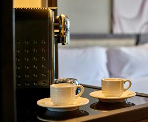 two cups of coffee on a counter with a espresso machine at Crowne Plaza - West Cairo Arkan, an IHG Hotel in 6th Of October