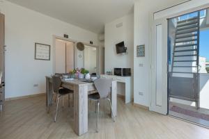 uma cozinha e sala de jantar com mesa e cadeiras em L`Ebrezza by BarbarHouse em Campomarino