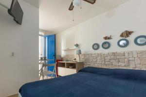 um quarto com uma cama azul e uma parede de pedra em L`Ebrezza by BarbarHouse em Campomarino