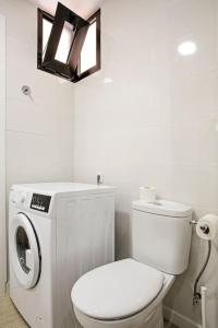 a bathroom with a toilet and a washing machine at Royal Suite Diamantes I With heated pool in Los Cristianos