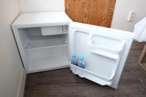 an open refrigerator with two bottles of water in it at Hostel Kpop in Seoul