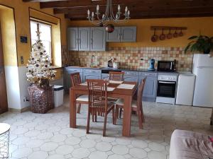 una cocina con mesa y sillas y un árbol de Navidad en Les Souchottes, charmante maisonnette en Bulligny