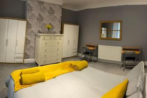 a bedroom with a bed with a yellow blanket on it at Seaside House-Next to the Beach, Sleeps 6 in South Shields