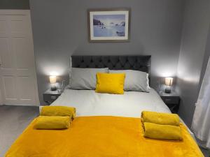 a bedroom with a large bed with two yellow pillows at Seaside House-Next to the Beach, Sleeps 6 in South Shields