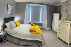 a bedroom with a bed with yellow towels on it at Seaside House-Next to the Beach, Sleeps 6 in South Shields