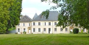 a large white house with a large yard at Maison d'hôtes Le Château de Puxe in Puxe