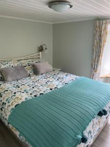 Un dormitorio con una cama con una manta azul. en The Old Thatch, Lemybrien en Waterford