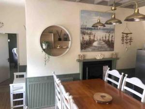 a dining room with a table and a mirror at The Old Thatch, Lemybrien in Waterford