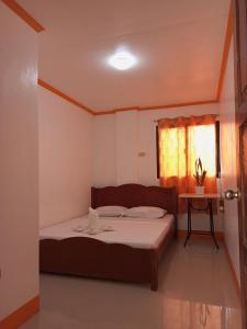 a small bedroom with a bed and a window at Lan Bless Pension House in Coron