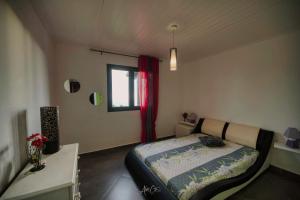 Schlafzimmer mit einem Bett und einem Fenster in der Unterkunft HAUT DE VILLA avec piscine chez JP in Petite Île