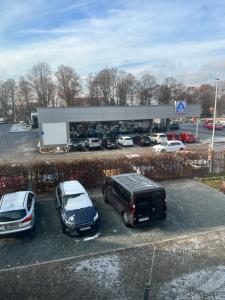two cars parked in a parking lot in front of a dealership at Ferienwohnung am Crisela in Ebersbach Sachsen