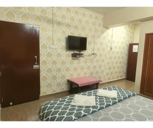 1 dormitorio con 1 cama y TV en la pared en Aqua Horizon, en Port Blair