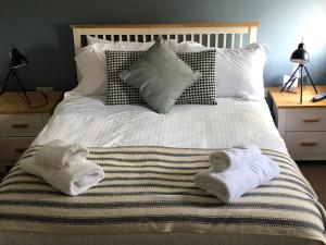 a bed with two towels on top of it at The Jolly Sailor in Orford