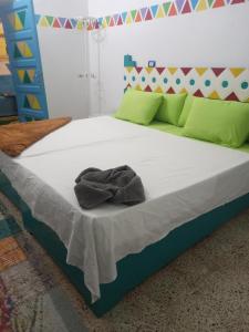 a bedroom with a large bed with white sheets and green pillows at Baba Dool in Aswan