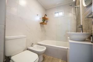 een witte badkamer met een toilet en een wastafel bij Corrientes Suites in Mar del Plata