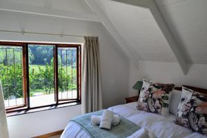 ダルストロアームにあるEagles Nestのベッドと大きな窓のある寝室