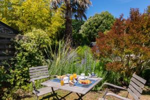 una mesa de picnic con comida en un jardín en Hôtel Traiteur Les Ormes, The Originals Relais, en Barneville-Carteret