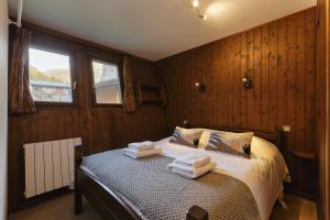La Maison De Montroc - Happy Rentals في شامونيه مون بلان: غرفة نوم عليها سرير وفوط