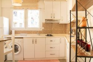 a kitchen with white cabinets and a washer and dryer at Vibran in Izmir