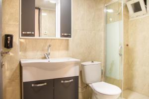 bagno con lavandino, servizi igienici e specchio di Vibran a Smirne