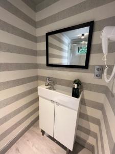 un bagno con pareti a righe e lavandino bianco di LA CASA CONTENEDOR a Saragozza