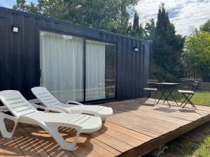a deck with two chairs and a table and a house at LA CASA CONTENEDOR in Zaragoza