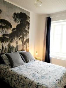 a bedroom with a bed with a painting on the wall at le gîte du fou logement 8 pers 13mn puy du fou in Saint-Amand-sur-Sèvre