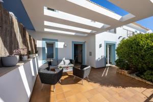 un patio con sofá, sillas y techo en Your Villa Algarve Private pool 5 min walk to beach, en Burgau
